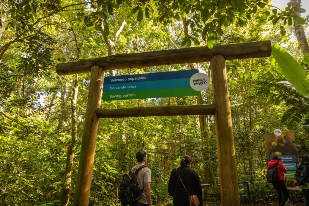 Visitantes na entrada de viveiro arborizado do Parque das Aves